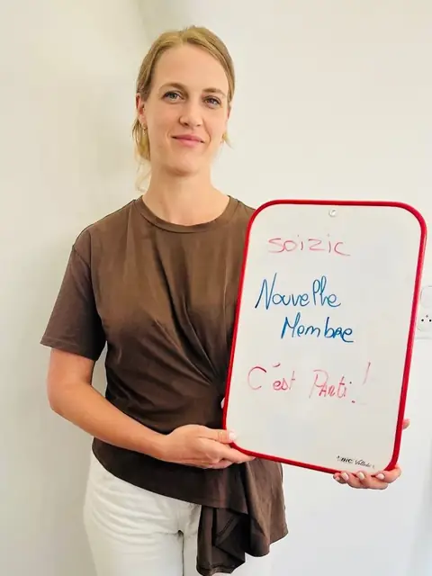 Une ardoise blanche, un bilan écrit dessus, une membre qui le présente depuis la salle du club