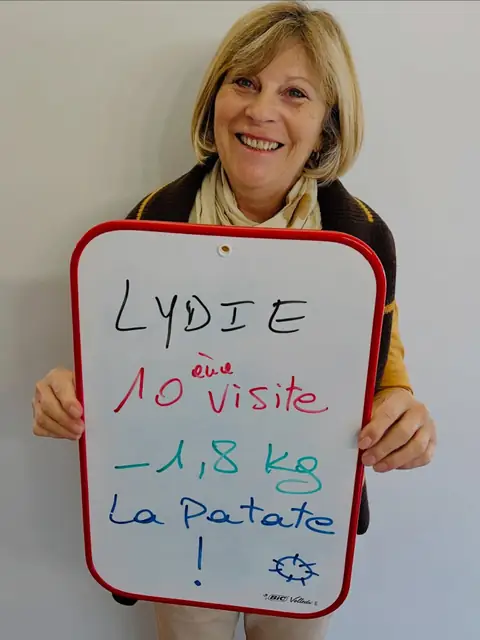 Une membre rayonnante dévoile, sur son ardoise, le résultat de son bilan au club