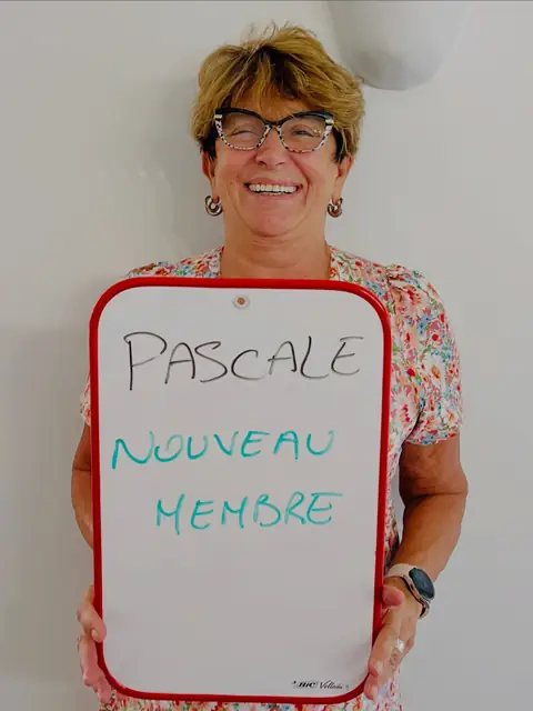 Une membre rayonnante dévoile, sur son ardoise, le résultat de son bilan au club